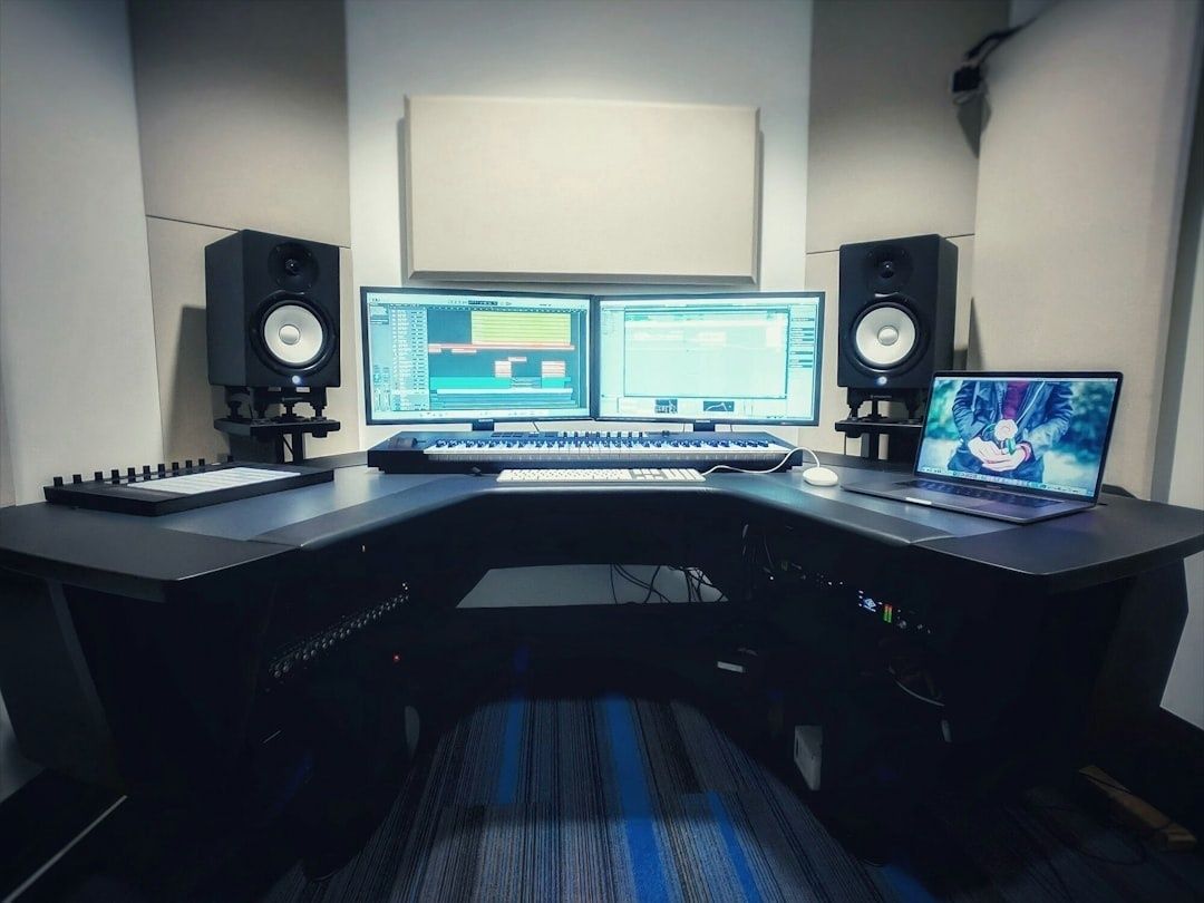 Ljudstudio med högtalare, skärmar och akustikpaneler vid skrivbord